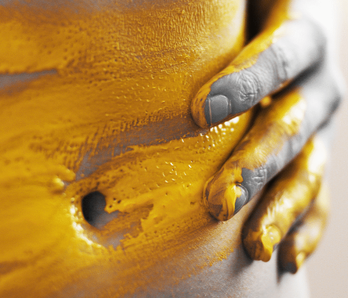 close up of stomach with yellow paint