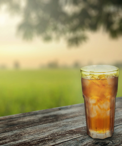 glass of ice tea on picnic table outdoors