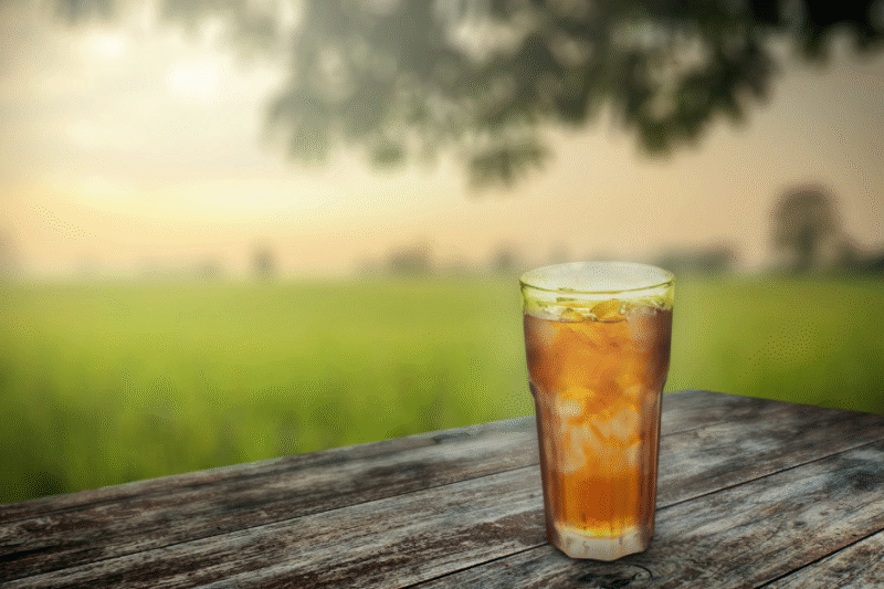 glass of ice tea on picnic table outdoors