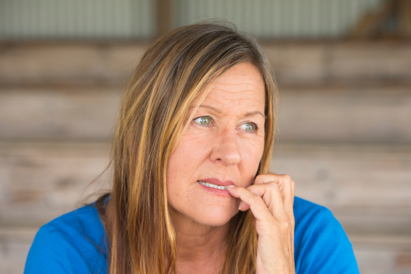 woman biting nails appearing checked out